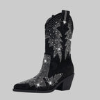 Black cowboy boot with silver rhinestone embellishments on a gray background