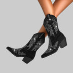 Black boots with silver embellishments on a gray background