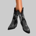 Black ankle boots with rhinestone embellishments on a gray background